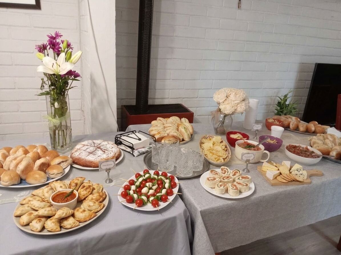 Mesa de catering de Abel Bakery's con panes, empanadas, brochetas y quesos