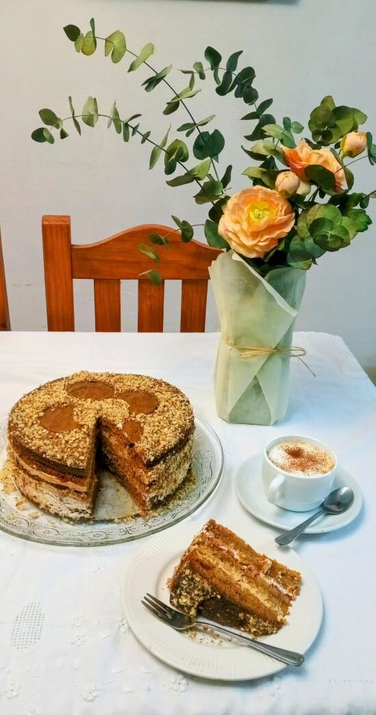 Torta mil hojas de Abel Bakery's servida con un café y una flor de fondo